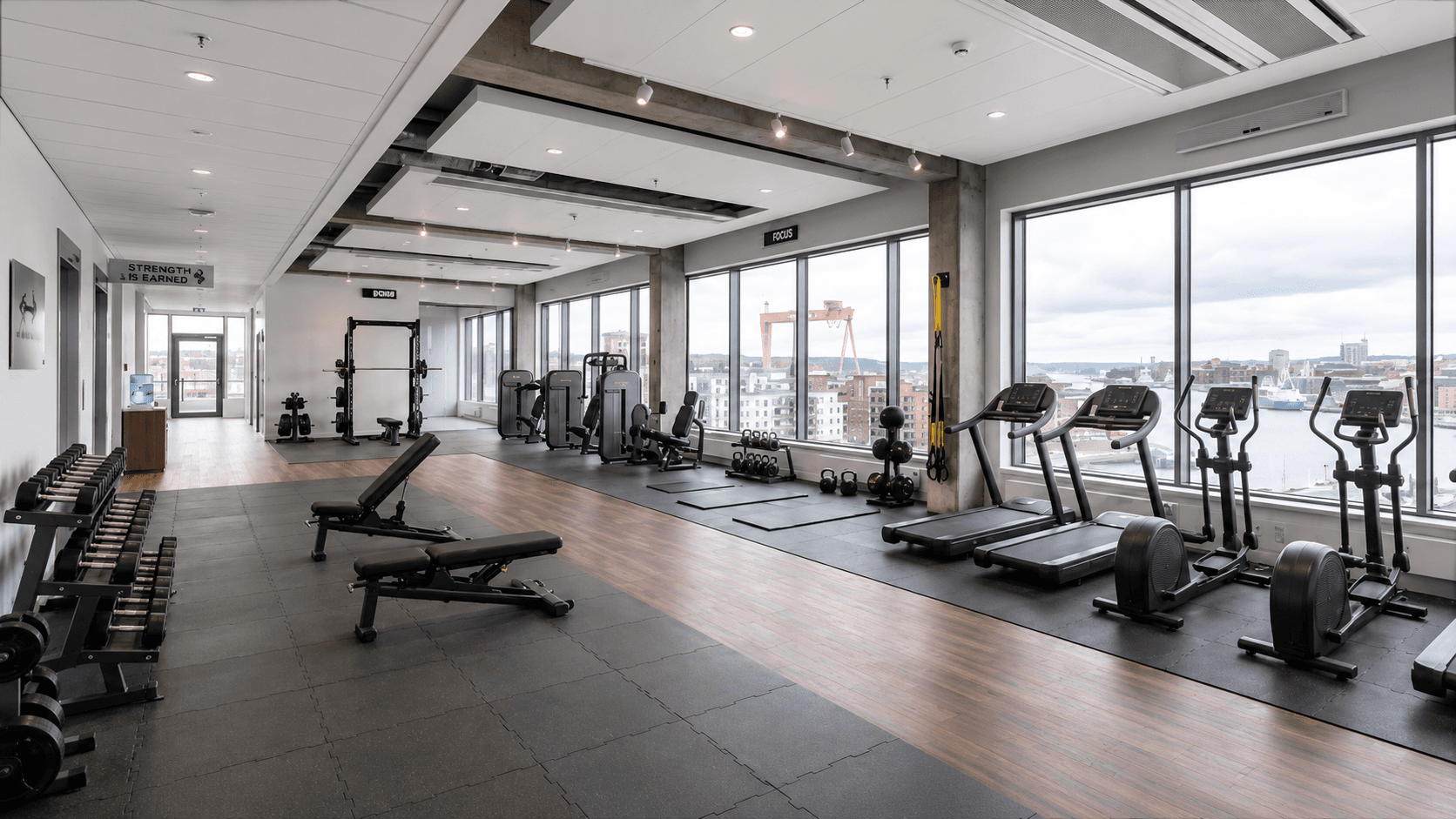 Same office space converted by the Bildgen agent into a fully-equipped gym with treadmills, free weights, and wooden flooring